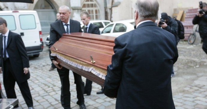 Členové pohřebního ústavu přenáší rakev do kostelu Pražská křižovatka