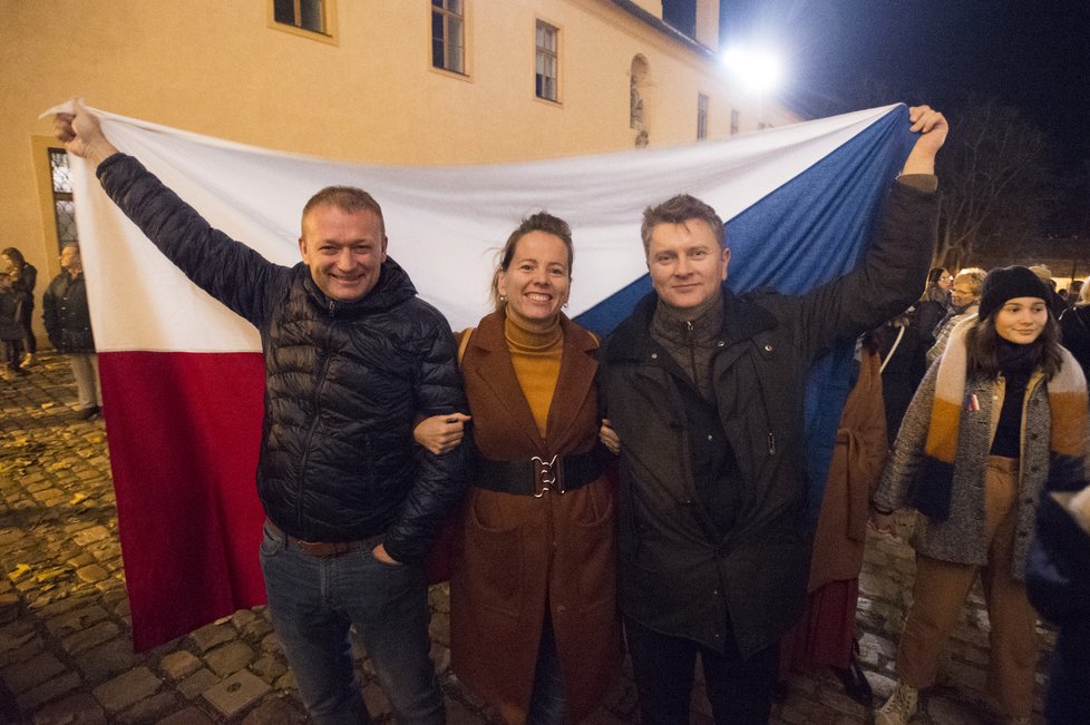 Lidé drží českou vlajku před vstupem do zámeckého areálu v Litomyšli, jehož okolí bylo 17. listopadu 2019 k 30. výročí sametové revoluce pojmenováno náměstím Václava Havla.