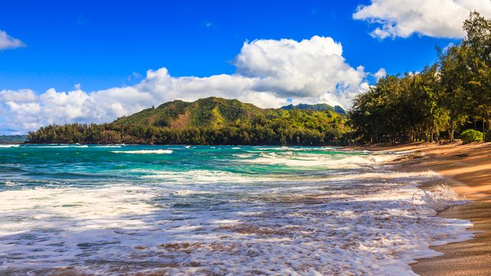Pláž na havajském ostrově Kauai. Část ostrova vlastní Mark Zuckerberg, který na své soukromé pláži serfuje.