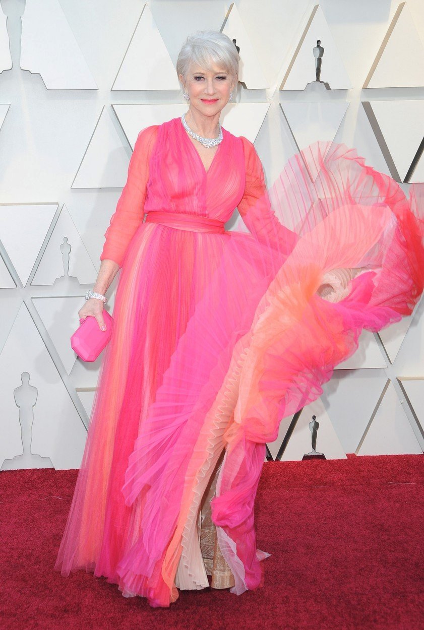 Oscarová herečka Helen Mirrenová oblékla lehoučkou róbu růžových, červených a oranžových odstínů a příchod po červeném koberci si náležitě užila