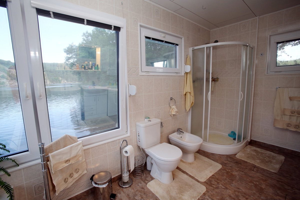 V další místnosti se nachází velice prostorná koupelna. No není tohle pravá romantika? Z velké vany se můžete dívat přímo na vodu.