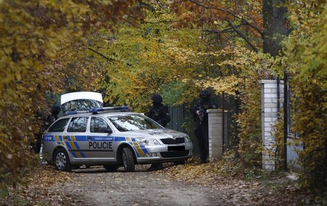 Po zuby ozbrojení policisté střeží příjezdovou cestu.