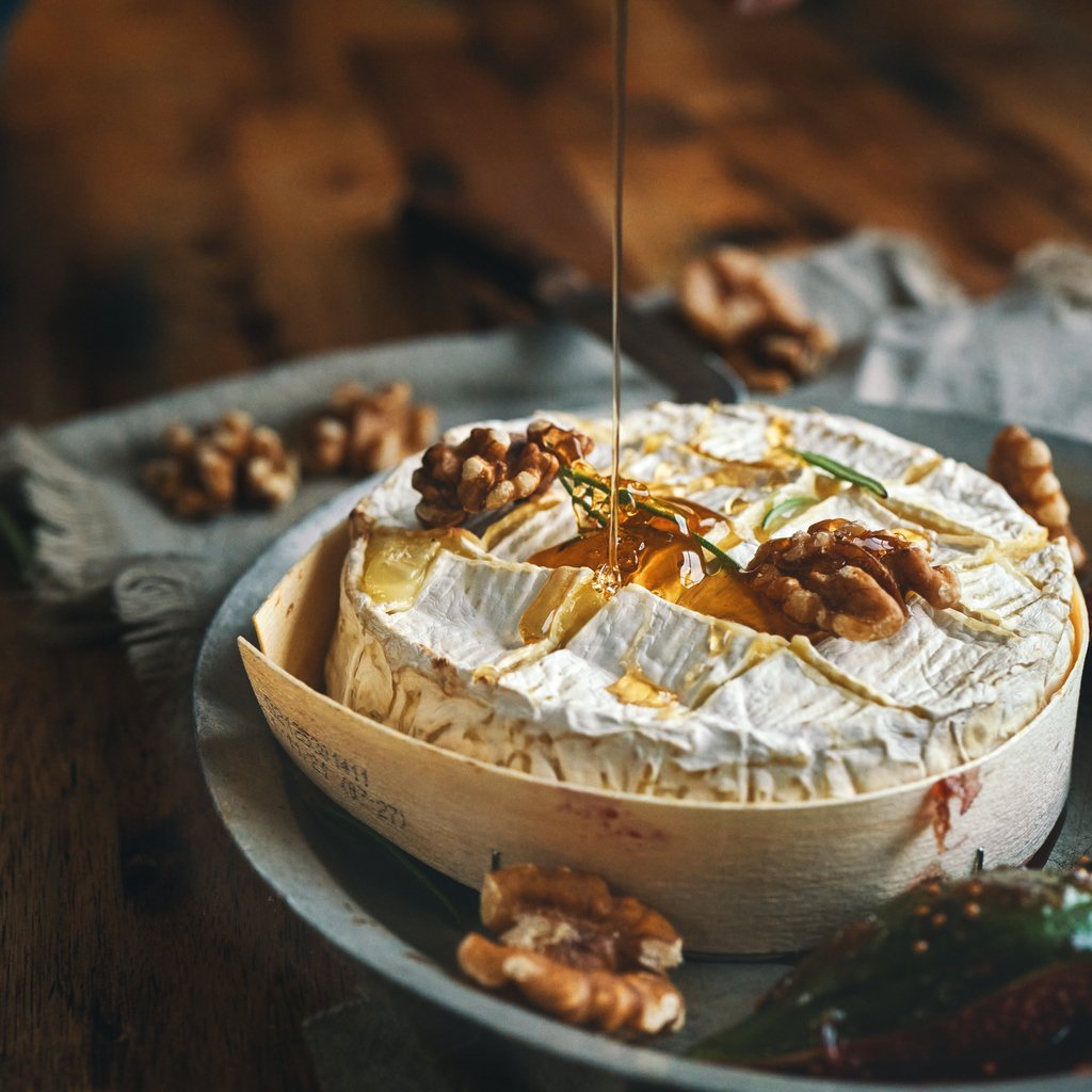 Rozpečený camembert s vlašskými ořechy a medem je delikátní chuťovkou k vínu