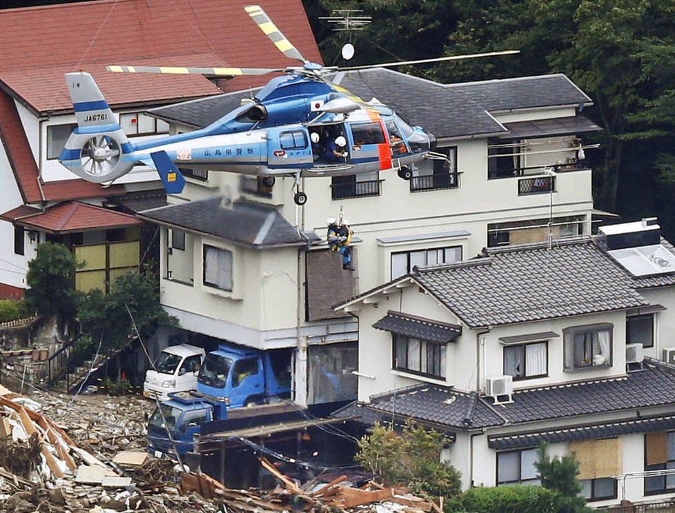 Záchranný vrtulník vytahuje místního obyvatele, kterého doma v Hirošimě uvěznil sesuv půdy.