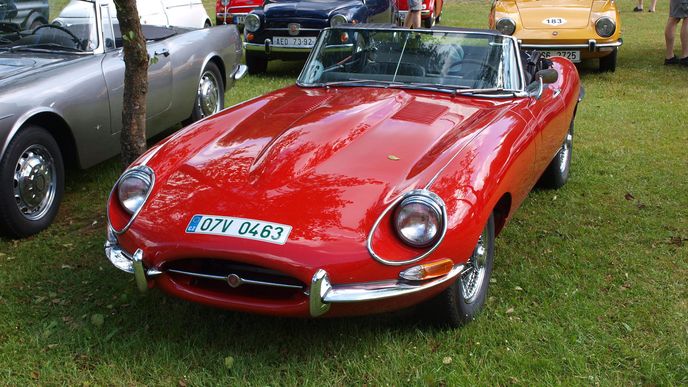 Historický Jaguar E-Type s typickou dlouhou přídí. Auto, které v roce 1961 obdivoval i Enzo Ferrari. Nejdříve se vyráběl jako dvoumístné kupé, později přibyla i čtyřmístná verze.