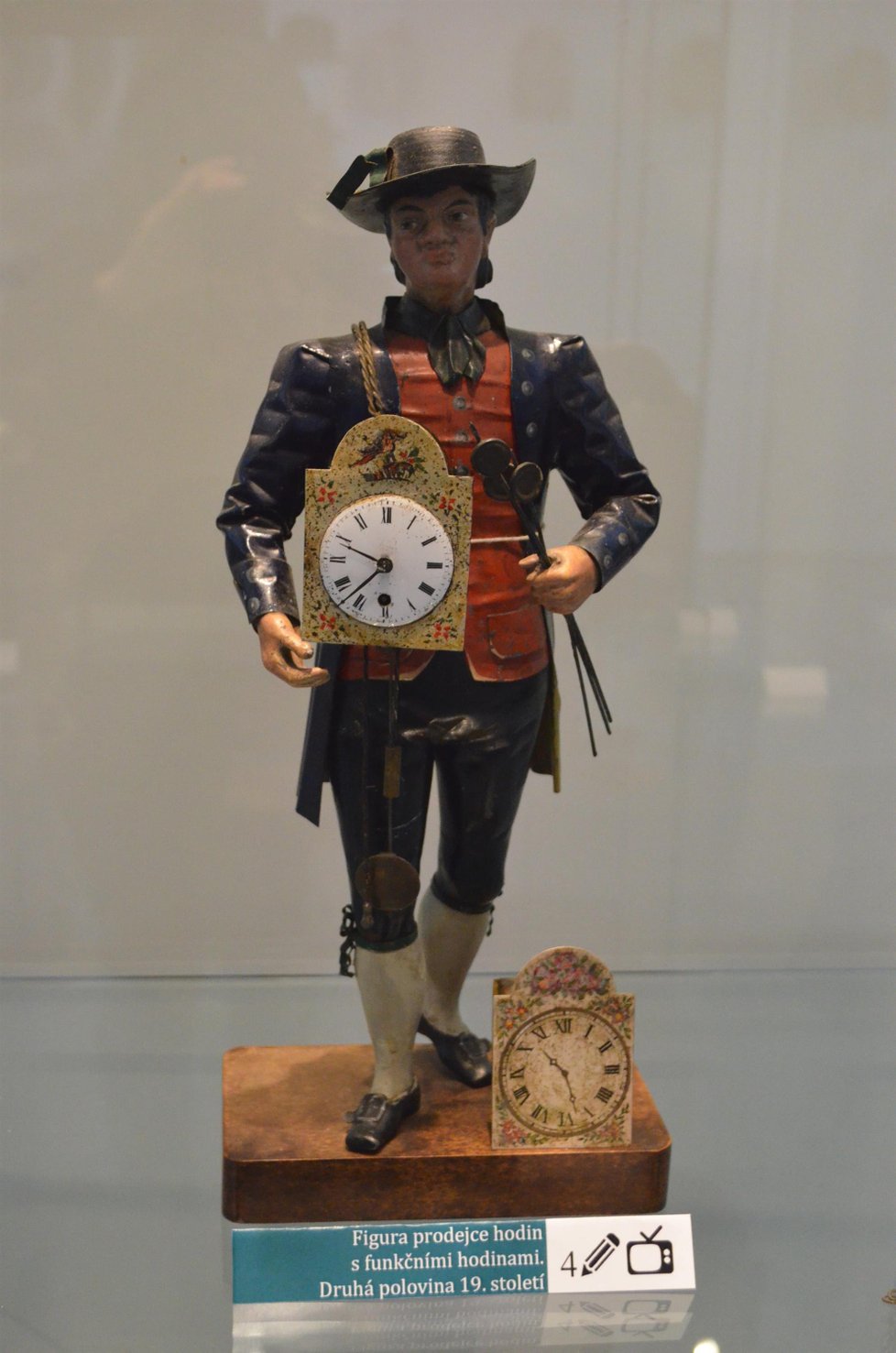 Prodejce hodin s funkčními hodinami z druhé poloviny 19. století.