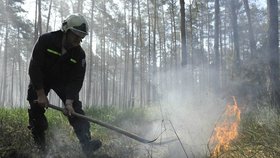 Hasič likviduje zbytky ohně na jednom z mnoha míst, které vzplály v Bzeneckém lese 24. května. Oheň se rozšířil na více než 400 hektarů půdy