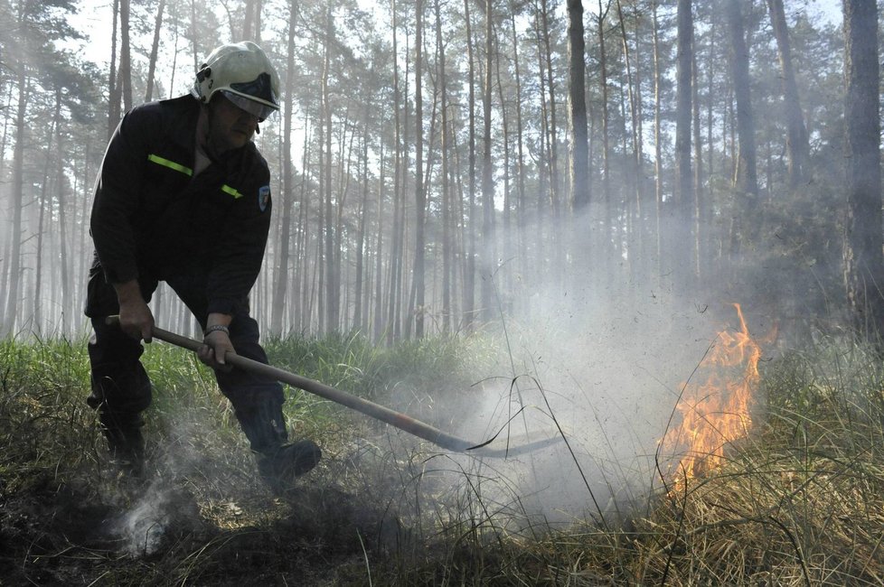 Hasič likviduje zbytky ohně na jednom z mnoha míst, která vzplála v Bzeneckém lese 24. května. Oheň se rozšířil na více než 400 hektarů půdy.