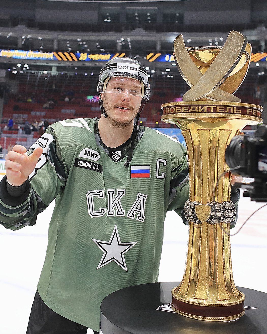 Dmitrij Jaškin jako kapitán Petrohradu ve vojensky laděných dresech s trofejí pro vítěze základní části KHL