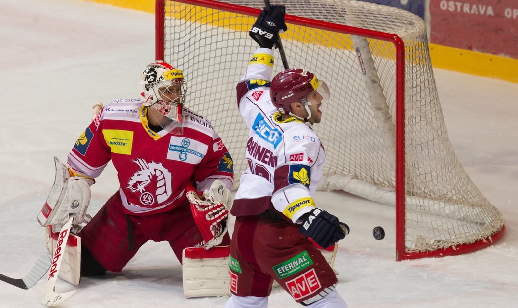 Třinecký brankář Petr Hamerlík inkasu první branku, v popředí se raduje střelec Ivan Rachůnek ze Sparty