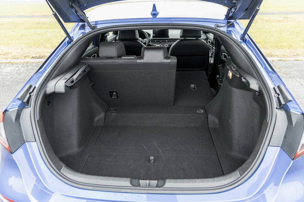 Civic nabízí kufr o objemu 415 litrů, což je méně než u předchozí generace. V podobě schodu do něj totiž zasahuje baterie hybridního systému.