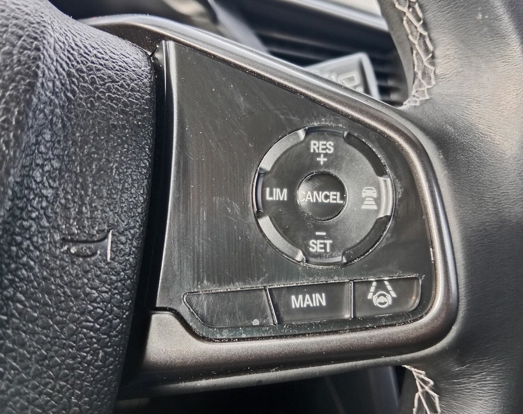U všech civiků najdete bohatý balík jízdních asistentů Honda Sensing, obsahující i adaptivní tempomat. Tlačítko vypínání jízdy v pruhu je v ideálním místě pod pravým palcem. Plexisklový povrch tlačítek na volantu je velmi nešťastný.