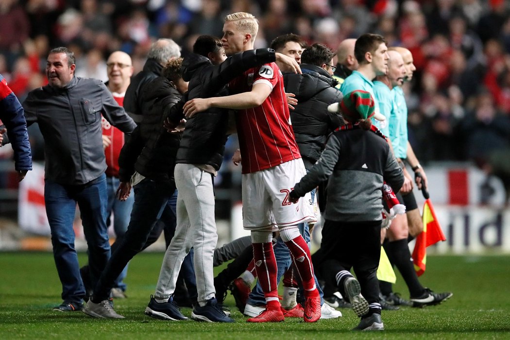 Hordur Magnusson z Bristolu slaví s fanoušky, kteří vtrhli na hrací plochu, triumf nad Manchesterem United