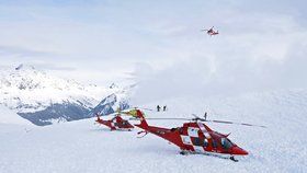 Záchranné vrtulníky a záchranáři po lavinové nehodě na vrcholku Piz Vilan.