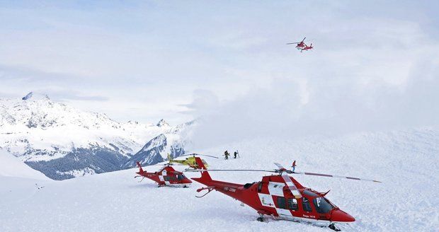 Záchranné vrtulníky a záchranáři po lavinové nehodě na vrcholku Piz Vilan.