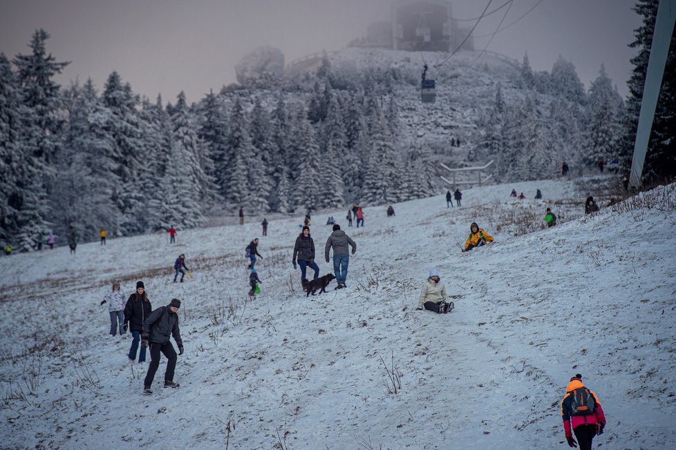 Do lyžařského areálu na Ještědu v Liberci přijelo mnoho lidí za zimními radovánkami, i když jsou lanovky nyní uzavřené kvůli vládním opatřením proti pandemii koronaviru. Přírodního sněhu je málo a uměle zasněžené sjezdovky tak využívají rodiny s dětmi k sáňkování, ale také lyžaři. Jen kopec si musí postaru vyšlápnout (30. 12. 2020).