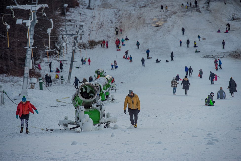 Do lyžařského areálu na Ještědu v Liberci přijelo mnoho lidí za zimními radovánkami, i když jsou lanovky nyní uzavřené kvůli vládním opatřením proti pandemii koronaviru. Přírodního sněhu je málo a uměle zasněžené sjezdovky tak využívají rodiny s dětmi k sáňkování, ale také lyžaři. Jen kopec si musí postaru vyšlápnout. (30. 12. 2020)
