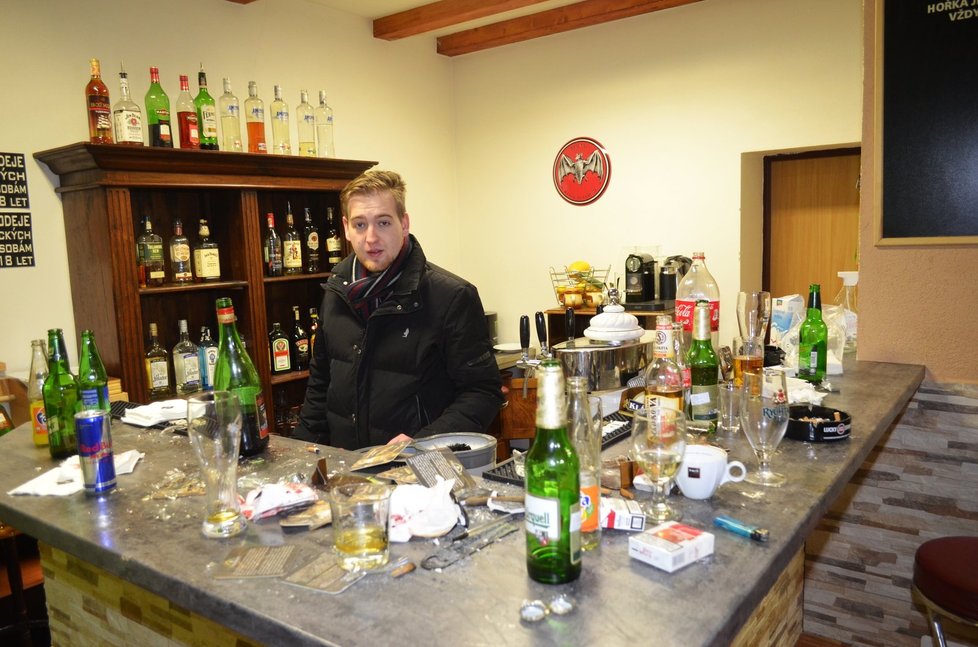 Provozovatel hospody Aleš Pokorný ukazuje místo v barovém pultu, kam se sekera zasekla.