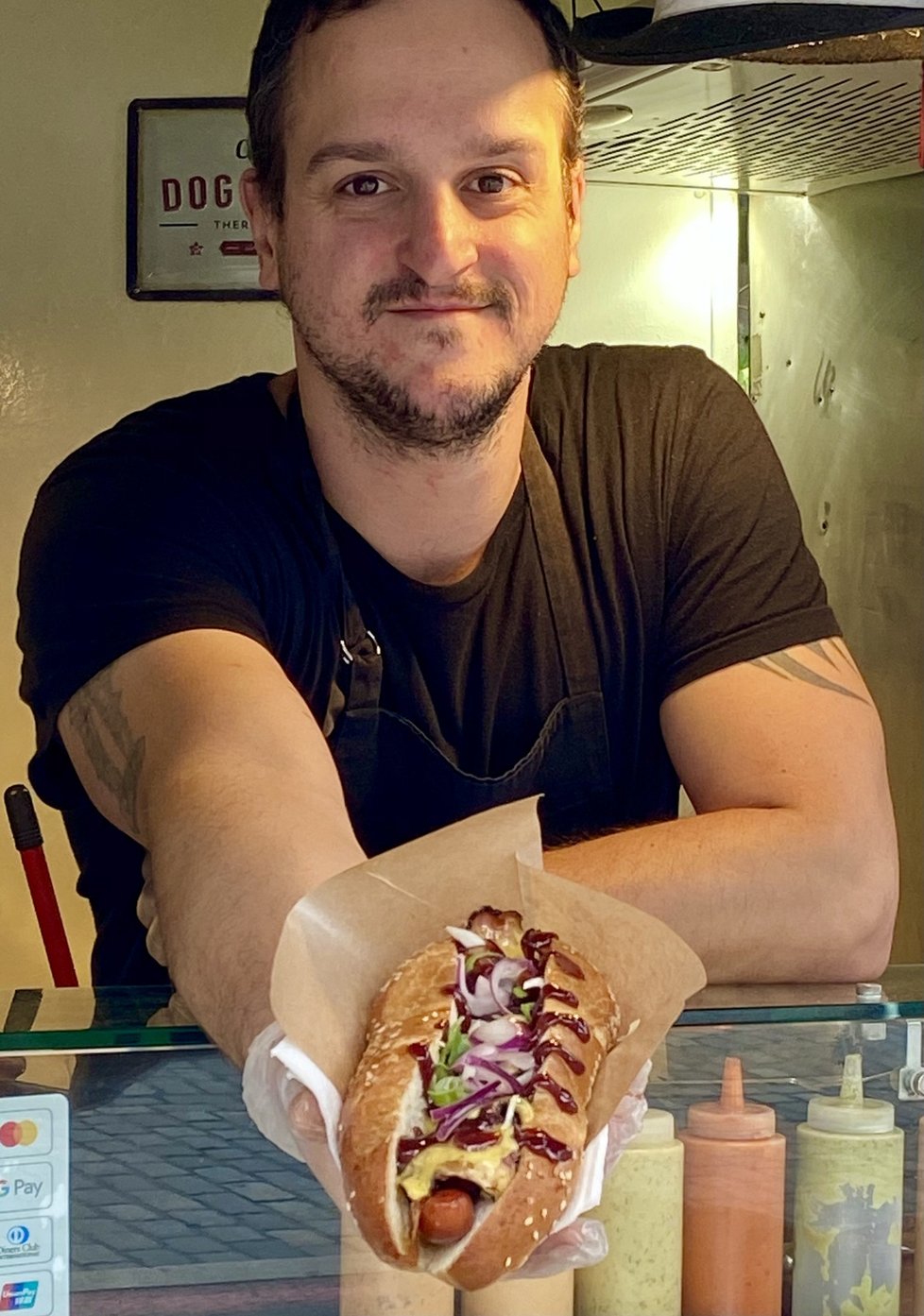 Před 10 lety se Bruno přestěhoval do Prahy, před rokem začal u metra Dejvická vařit a připravovat poctivé hot dogy.