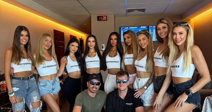 Hostesky před letem ve VIP salonku. Čas ukazuje skoro půl dvanácté.