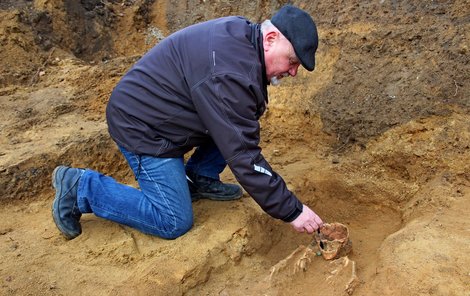 Luděk Galuška štětečkem odstraňuje nános písku.