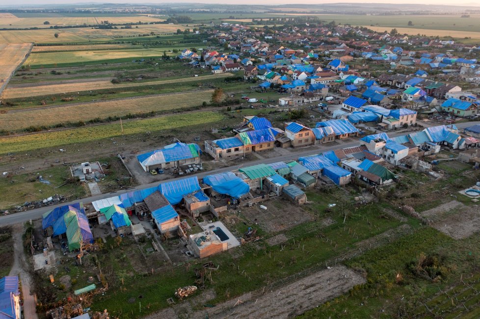 Obec Hrušky po ničivém tornádu: Domy mají provizorní modrou střechu z plachet (28.6.2021).