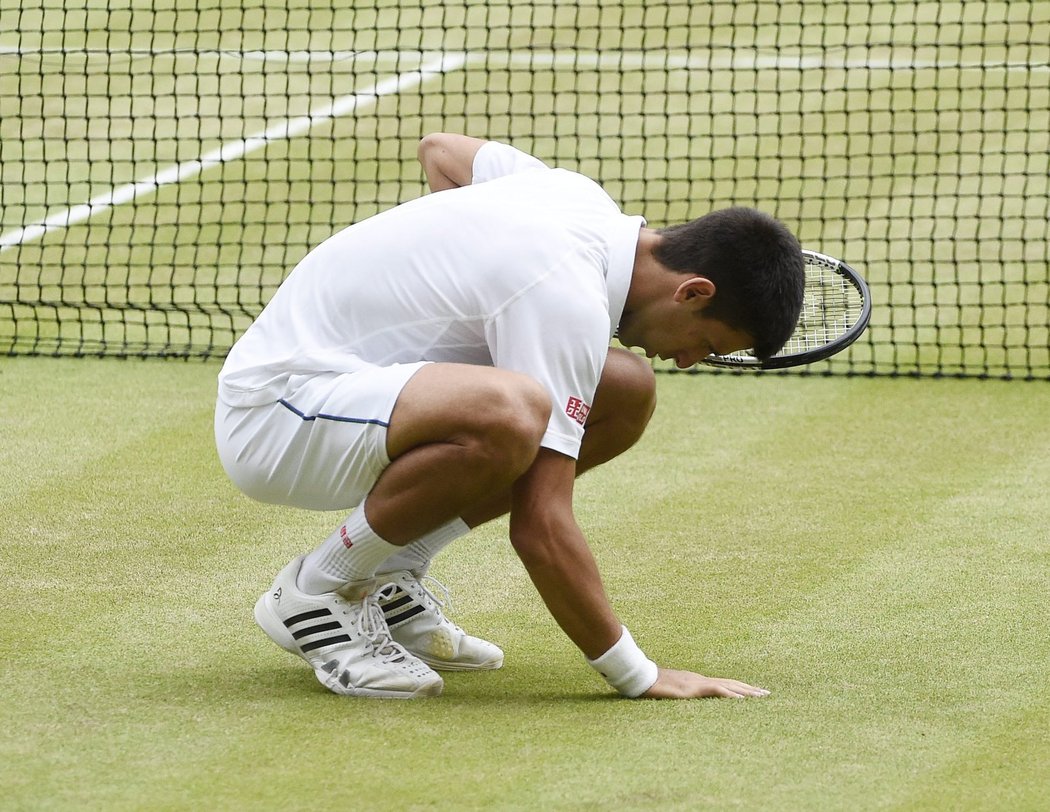 Je to tam! Djokovič se dotýká posvátného wimbledonského trávníku, kde už potřetí získal titul