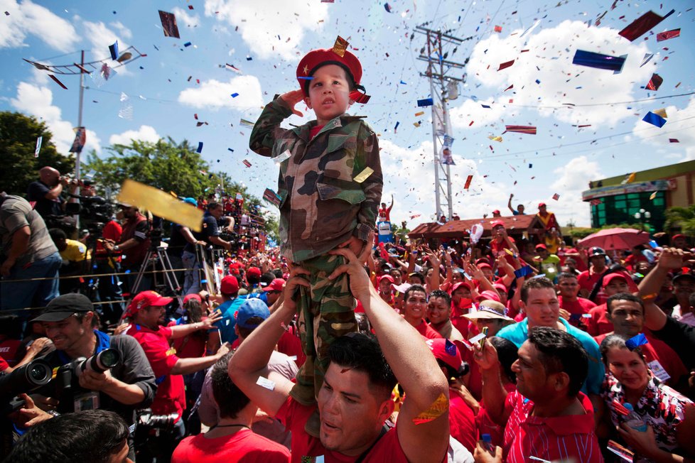 Chlapec ve vojenské uniformě salutuje socialistickému prezidentovi Chávezovi