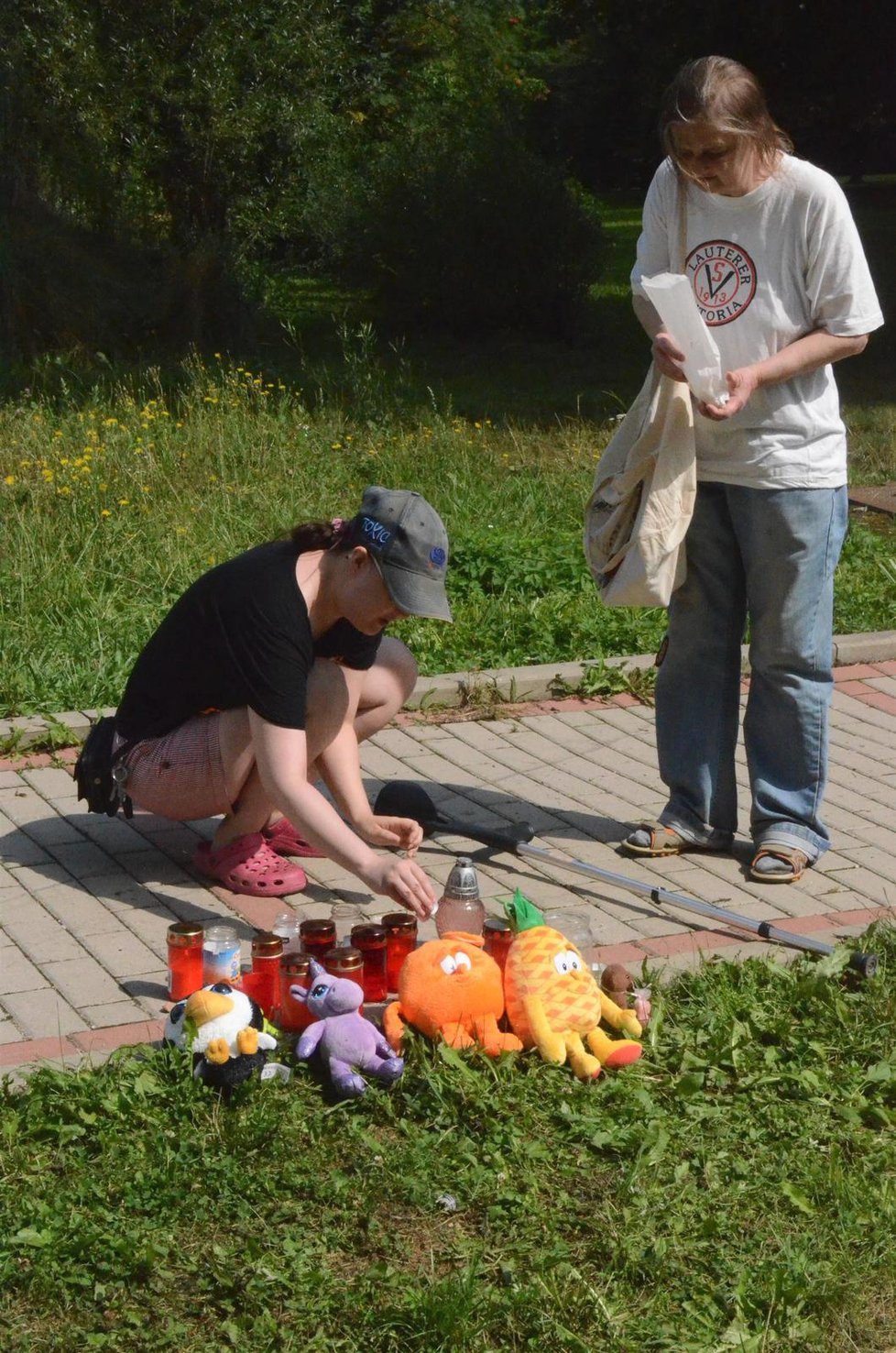 Lidé na místo tragédie přinášeli plyšové hračky a svíčky.
