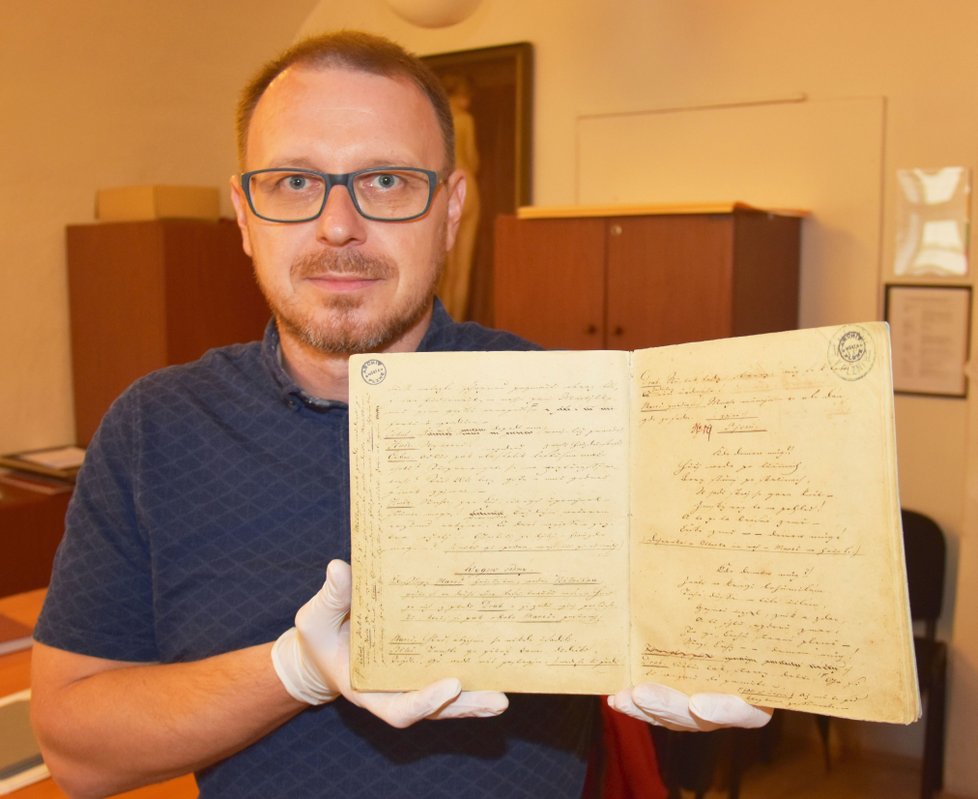 Šéf archivu Adam Skála ukazuje hru Fidlovačka, kde je na pravé straně text české hymny Kde domov můj. 
