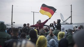Uprchlíci v Idomeni na řecko-makedonské hranici s německými vlajkami. Právě do Německa se chtějí dostat.