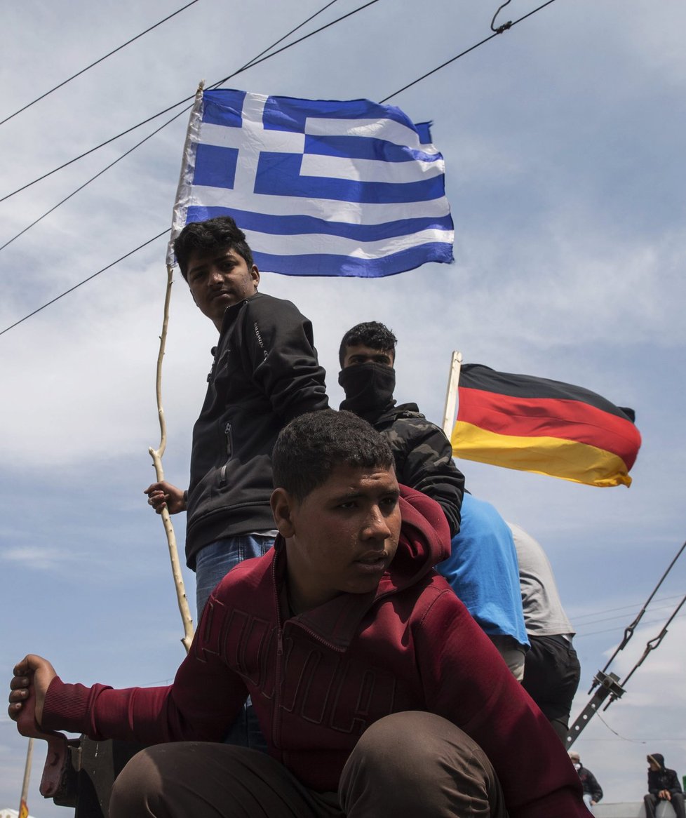 Uprchlíci v Idomeni na řecko-makedonské hranici s německými vlajkami. Právě do Německa se chtějí dostat.