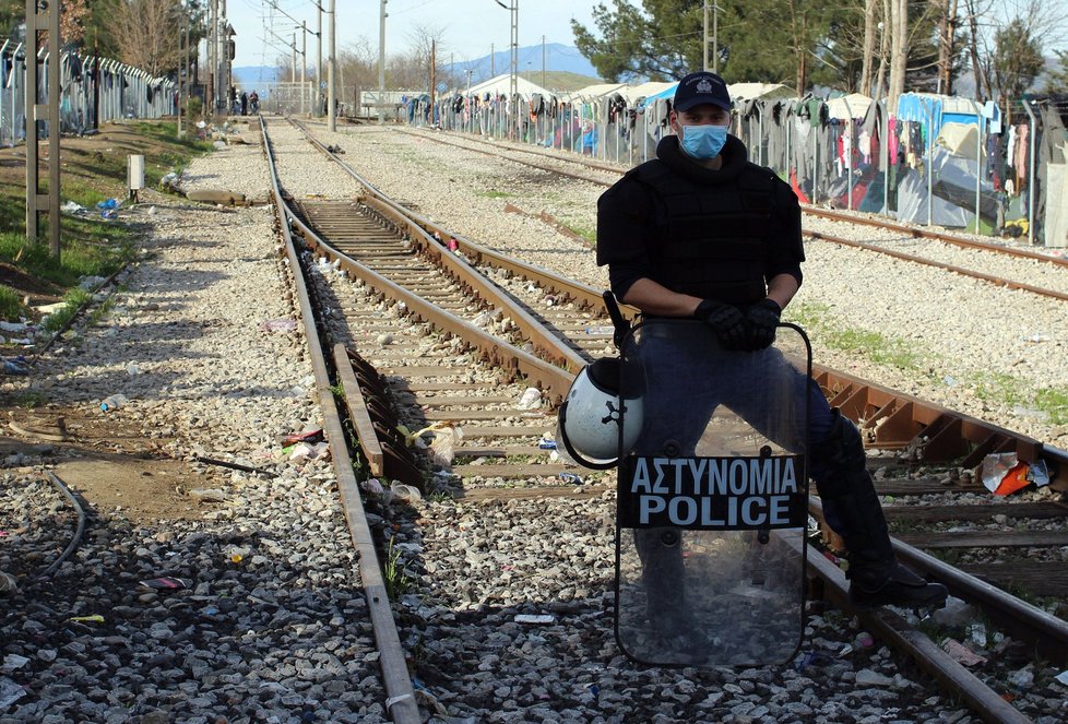 Policista hlídá koleje a přilehlou hranici.