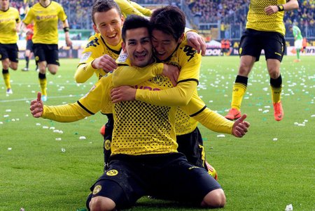 Dortmundský záložník Ilkay Gündogan se raduje z gólu v síti Wolfsburgu, gratulují mu Šinži Kagawa (vpravo) a Ivan Perišič.