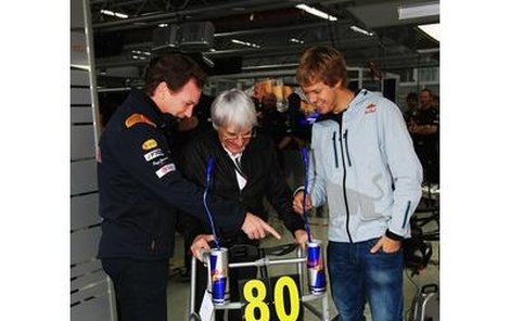 Bernie Eccelstone (uprostřed) se hned zajímal o funkce netradičního dárku od Sebastiana Vettela (vpravo).