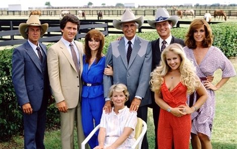 Ewingové v plné síle: zleva Steve Kanaly (63), Patrick Duffy (60), Victoria Principal (59), Jim Davis (†71, zemřel v roce 1981), Larry Hagman (78), Charlene Tilton (50), Linda Gray (69), v křesle Barbara Bel Geddes (†82, zemřela v roce 2005).