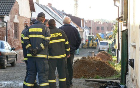 Hasiči stojí u těla zakrytého černou plachtou v ulici, kde k tragédii došlo.