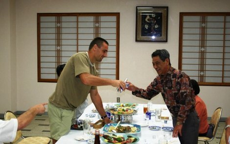 Host Šebrle rozlévá svým hostitelům saké, tradiční japonskou kořalku.