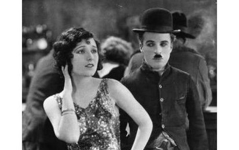 I v tomhle záběru žena vedle Charlie Chaplina působí, jako by měla mobil u ucha. Záhada se však týká jiného záběru a jiné ženy.