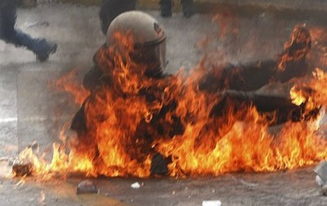 Jeden z policistů se po zásahu zápalnou lahví ocitl v plamenech.