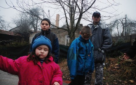 Jiří Dvořáček se svými dětmi Jirkou, Tomášem a Karolinkou před ruinami shořelého domu.