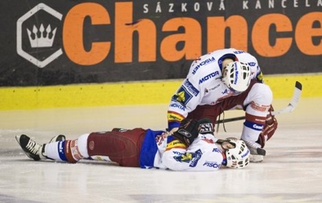 Kuchejda leží na ledě totálně K.O., první ze spoluhráčů kontroluje jeho zdravotní stav.