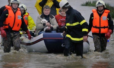 Manžele Vlastu a Jiřího Němčákovy, které povodeň postihla i před třinácti lety, vezli do bezpečí hasiči.