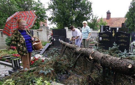 Pracovník radnice v Bořeticíh na Břeclavsku Václav Pazderka odstraňuje jeden ze spadlých stromů, které při noční bouřce poškodily na místním hřbitově několik hrobů.