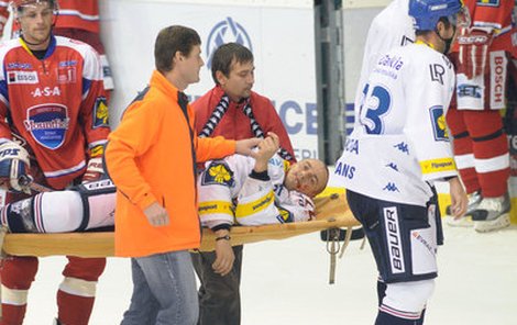 Silně otřesený Viktor Ujčík opouští na nosítkách led.