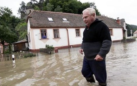 Stanislav Pokorný se brodí zaplavenou ulicí v obci Podhradí nad Dyjí na Znojemsku, kterou po vydatných deštích zatopila řeka Dyje.