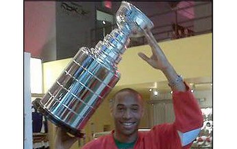 Thierry Henry v triku Detroitu se Stanley Cupem nad hlavou.
