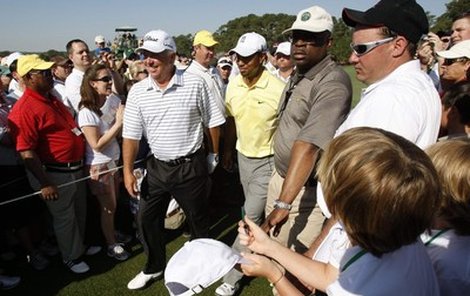 Tigera Woodse chrání před davem hned několik mužů.