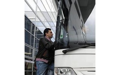 Trenér Růžička nastupuje do odřeného autobusu.