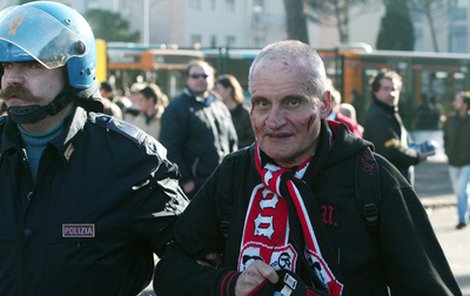 Válka v Bergamu. Policista odvádí zkrvaveného fanouška AC Milán.